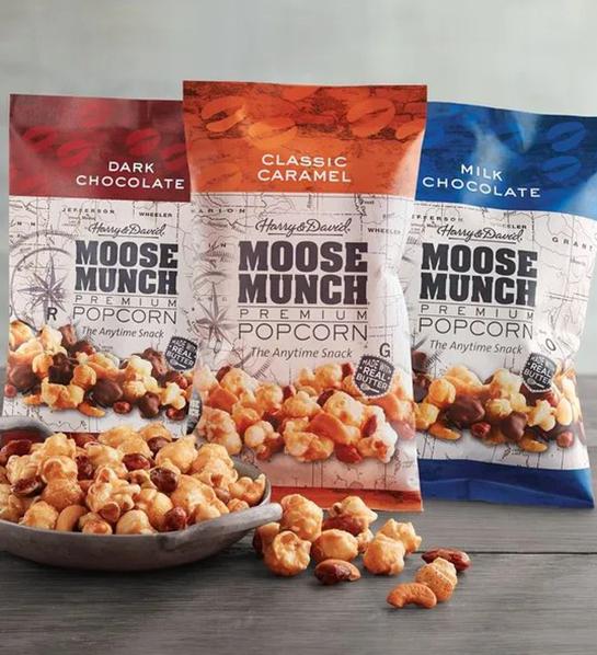 A photo of Easter basket stuffers with three bags of Moose Munch with a bowl full of Moose Munch in front.