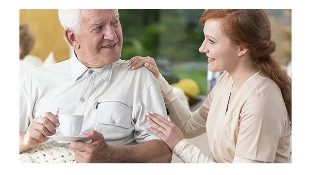 Caregiver helping an elderly man.