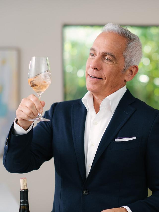 Geoffrey Zakarian swirling a glass of rosé wine.