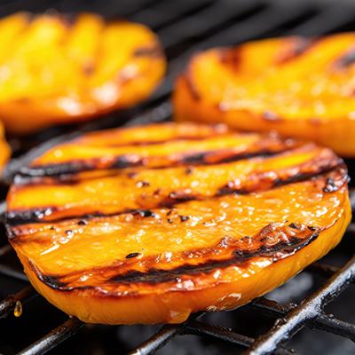 Slices of grilled mango on a grill.
